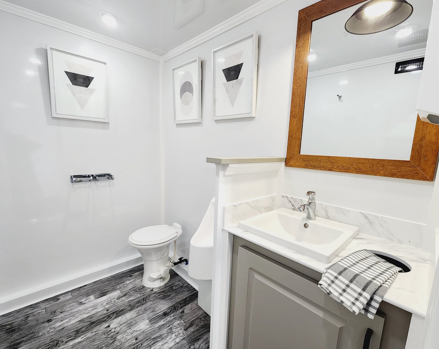 Interior of men's suite with toilet, urinal, and marble vanity