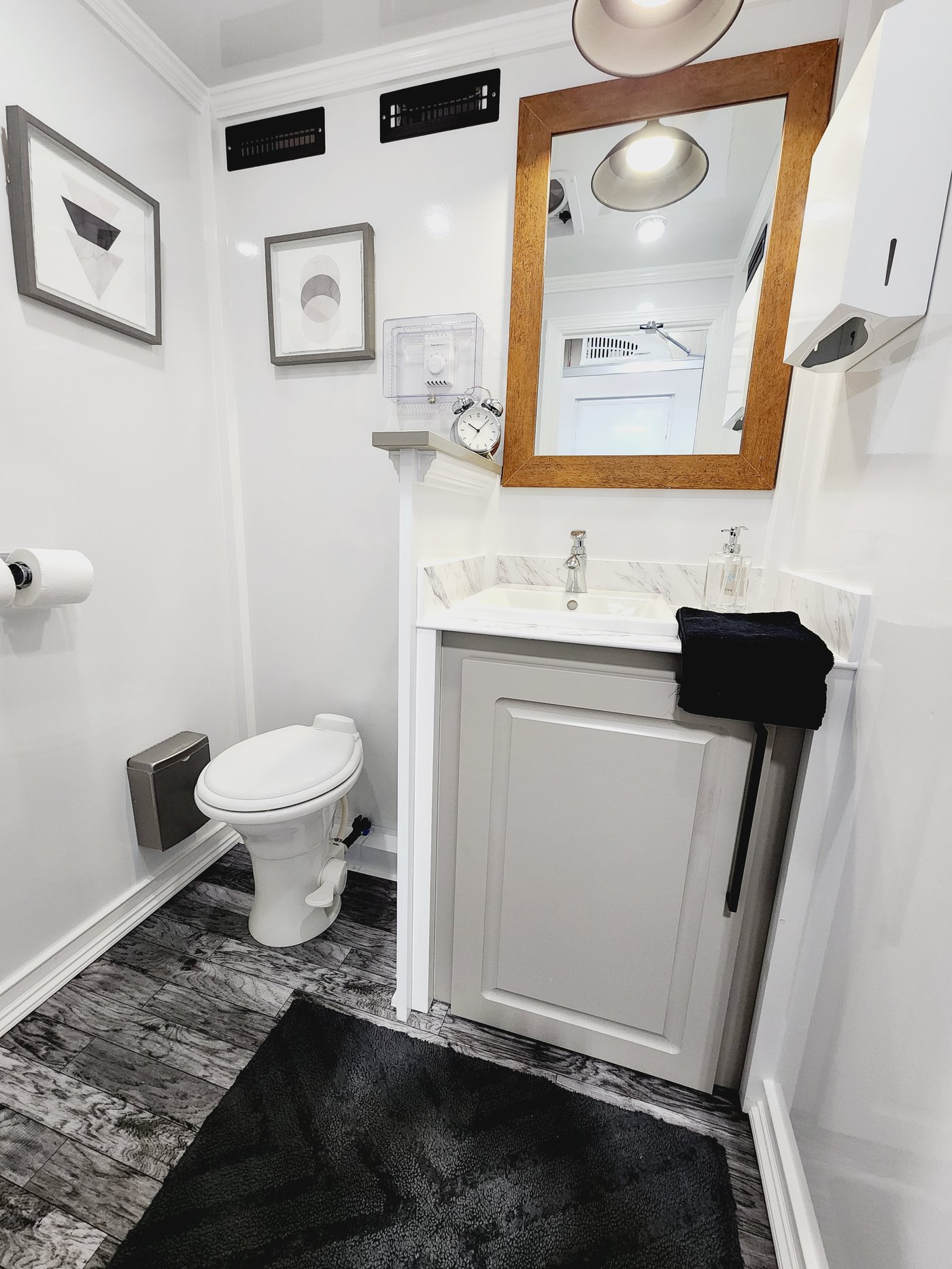 Interior of women's suite with marble vanity and wood-framed mirror